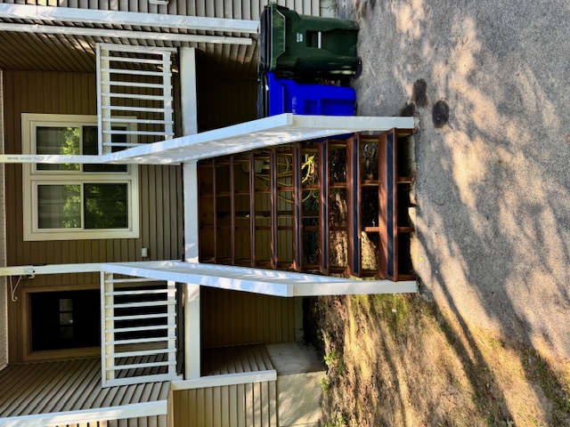 Wide view of a rebuilt stair run and repaired deck entry in Goffstown